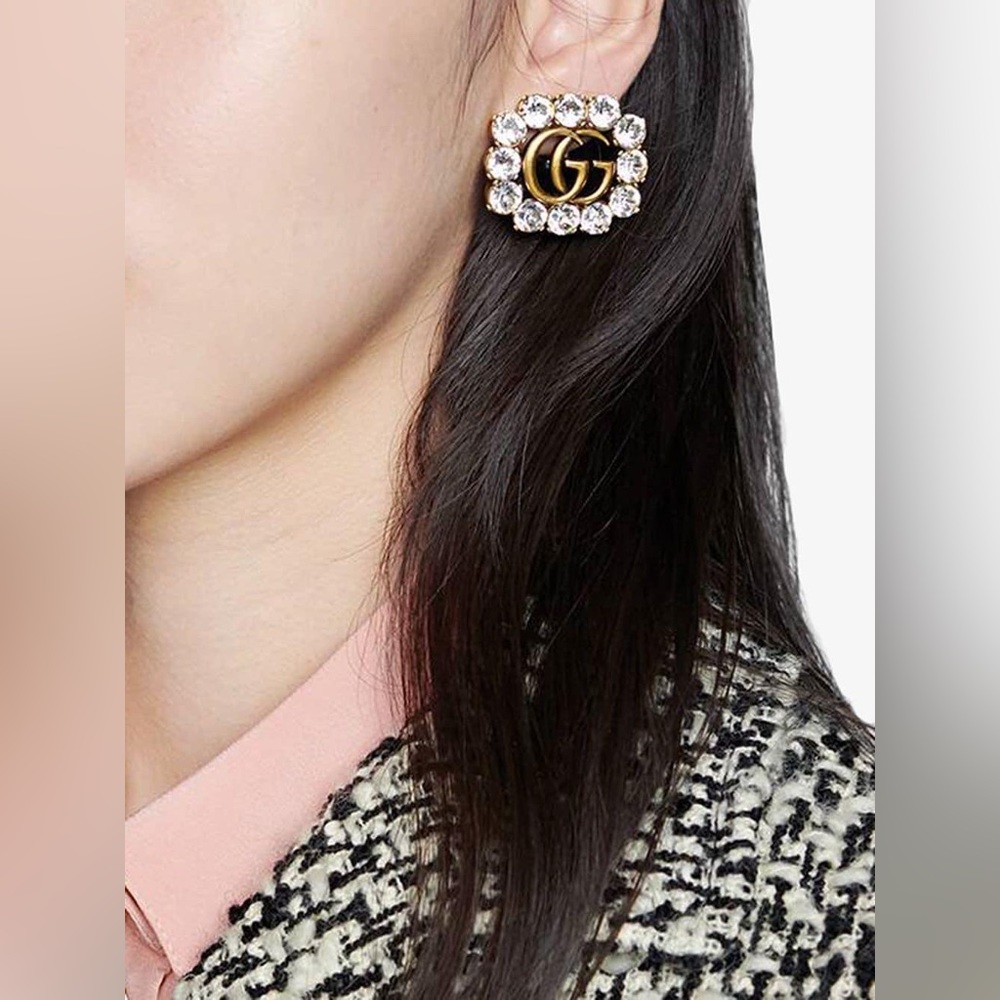 GUCCI Crystal Double G earrings in aged gold finish.